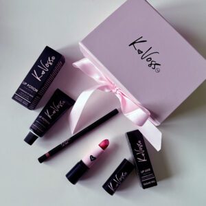 Luxurious Koloss makeup set with lipstick, foundation, and more in elegant black and pink packaging.